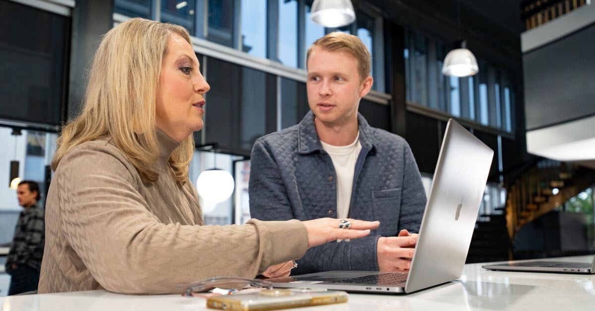 Lisa Nelson and Corbin Headlee discussing marketing ideas at laptop