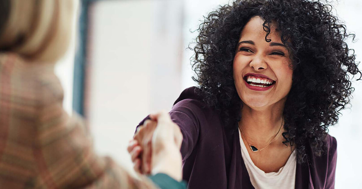 happy woman shaking someone's hand